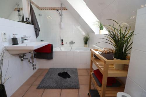 a bathroom with a sink and a bath tub at Oewern Diek App 09 in Wustrow