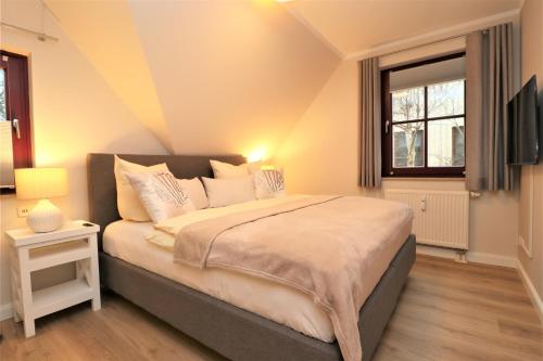 ein Schlafzimmer mit einem großen Bett und einem Fernseher in der Unterkunft Oewern Diek App 58 in Wustrow