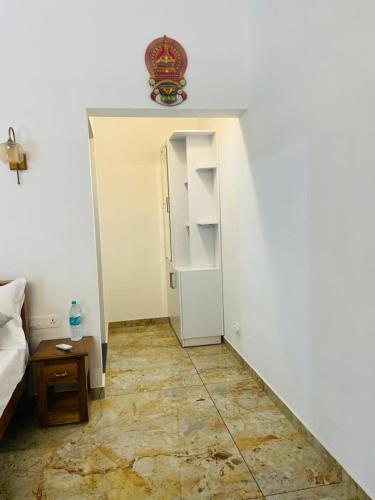 a small room with a bed and a refrigerator at SALT LIFE MARARI BEACH VILLA in Mararikulam