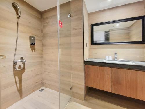 uma casa de banho com um chuveiro e um lavatório. em CHECK inn Taichung Wenxin Zhongqing em Taichung