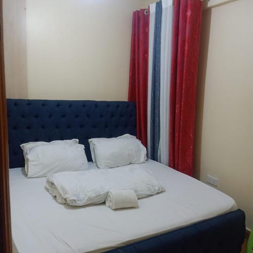 ナイロビにあるShanDezのベッド(青いヘッドボード、白いシーツ、枕付)