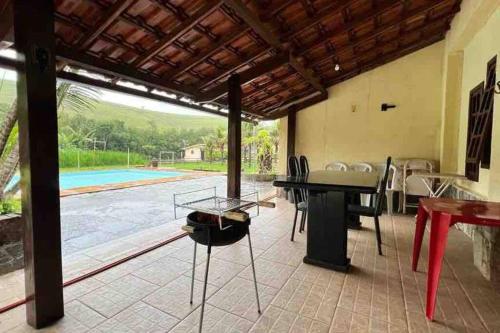 帕蒂杜阿爾費里斯的住宿－Sítio com 3 suítes +3 quartos, campo e piscina.，一个带桌椅的庭院和一个游泳池