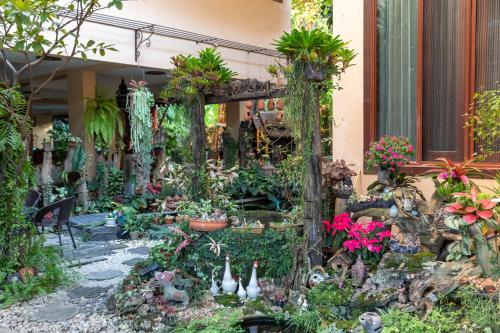a garden in front of a house with plants at At Chiang Mai Hotel in Chiang Mai