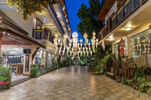 an empty shopping mall with potted plants and chandeliers at At Chiang Mai Hotel in Chiang Mai