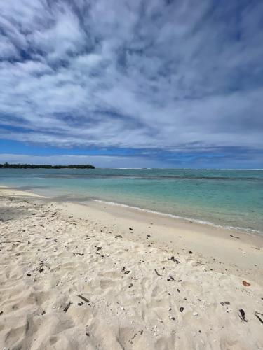 a sandy beach with the ocean and a cloudy sky at Parea Lodge Huahine BUNGALOW F2 #Miti in Parea