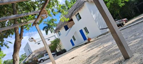 una casa blanca con techo de paja en Posada Mykonos, en Bacalar