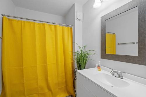 baño con cortina de ducha amarilla y lavamanos en Spacious home- near Airport, Crabtree Mall & Food en Raleigh