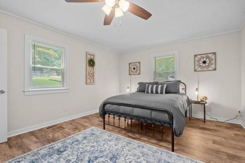 a bedroom with a bed and a ceiling fan at Spacious home- near Airport, Crabtree Mall & Food in Raleigh