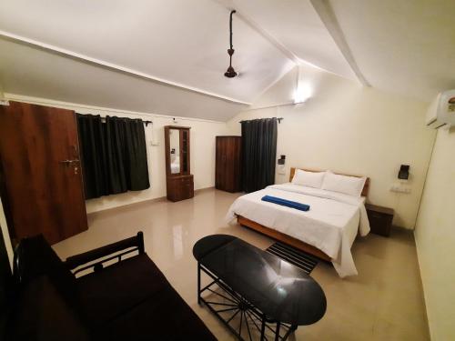 a bedroom with a bed and a chair in it at Jardim De Sanfrancisco in Agonda