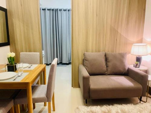 Una sala de estar con una silla y una mesa. en LoveFame 8M, en Manila