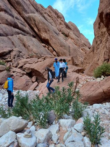 a group of people walking through a canyon at Maison D'hôte La Vallée Des Figues in Tamellalt