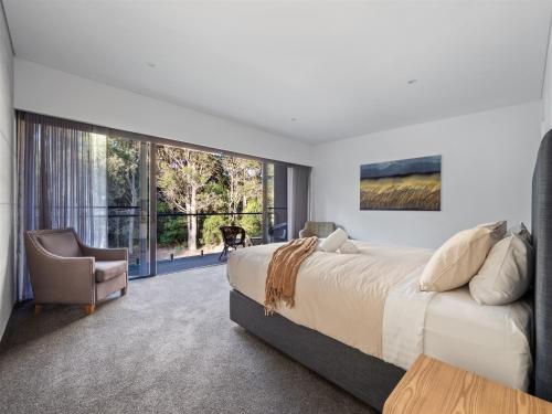 a bedroom with a large bed and a chair at SpaceNature in Margaret River Town