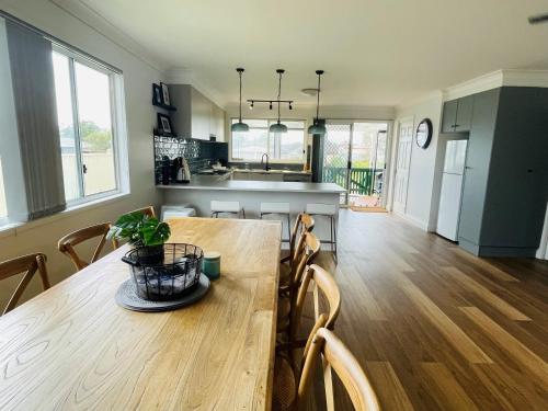 a kitchen and dining room with a wooden table at Rose's Cottage in Sanctuary Point