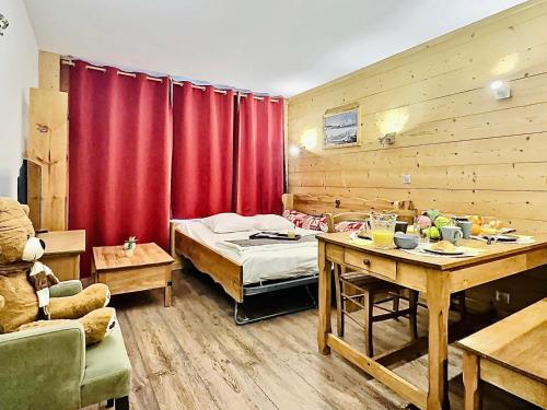 Cette chambre comprend un lit et un rideau rouge. dans l'établissement Sublime T2 rénové, tout confort, proche centre Val Claret - FR-1-411-914, à Tignes