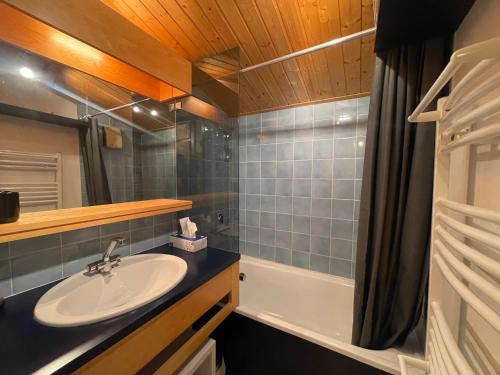 une salle de bain avec un lavabo et une baignoire dans l'établissement Appartement Chaleureux avec Balcons au Coeur de Samoëns, Proche Ski-Bus - FR-1-624-147, à Samoëns