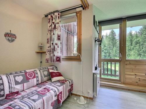 un salon avec un canapé et une fenêtre dans l'établissement Studio divisible au pied des pistes avec balcon, WiFi et lave-linge - FR-1-455-250, à La Plagne Tarentaise