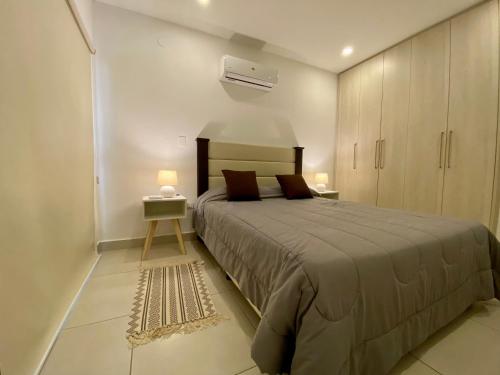 Hostalito Las Mercedes في أسونسيون: غرفة نوم بسرير كبير وموقف ليلي