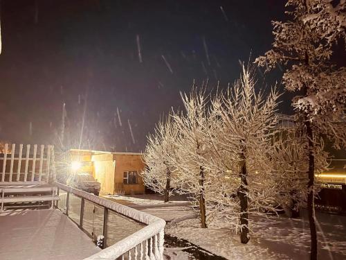 a snow covered yard with a fence and trees at Kharkhorin hostel in Harhorin