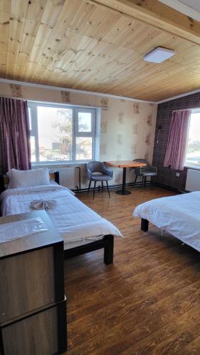 a bedroom with two beds and a table and chairs at Kharkhorin hostel in Harhorin