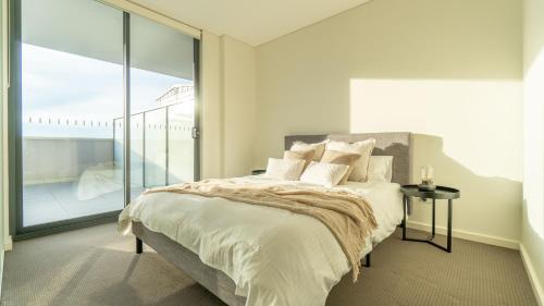 een slaapkamer met een bed en een groot raam bij Central Canterbury Charm Sky View Free Parking in Sydney