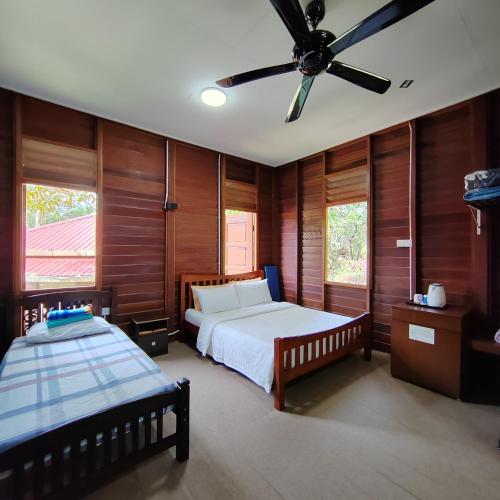 Pedas的住宿－D'Bukit Forest，一间卧室配有两张床和吊扇