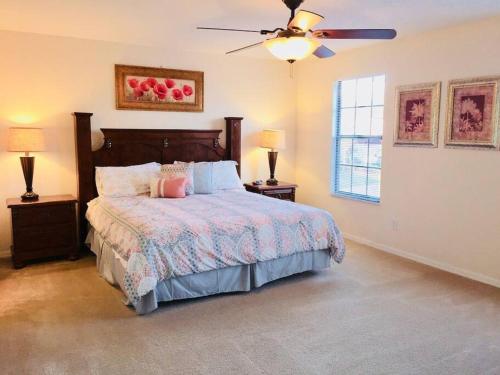 Un dormitorio con una cama y un ventilador de techo. en Family Disney Home, Pool, Spa, in Gated Resort -126, en Orlando