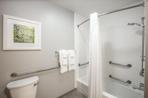 y baño blanco con aseo y ducha. en Holiday Inn Express Hotel & Suites Columbus, an IHG Hotel en Columbus