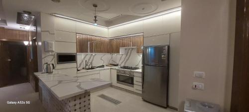 Il comprend une grande cuisine équipée d'un réfrigérateur et d'une cuisinière. dans l'établissement Resort altayar Villa altayar 1 Aqua Park with Sea View, à Sidi Krir