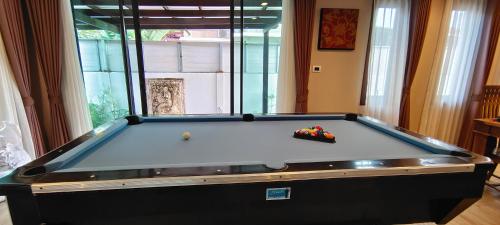 a pool table sitting in a living room with at Baan Natcha Villa in Pattaya Central