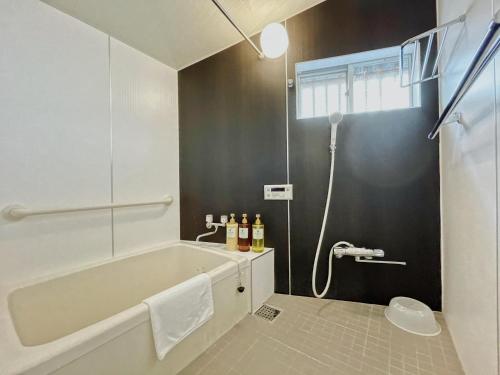 a bathroom with a bath tub and a shower at East Shin-Osaka Hotel Apartment in Osaka