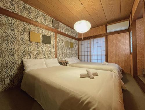 a room with two beds in a room at East Shin-Osaka Hotel Apartment in Osaka