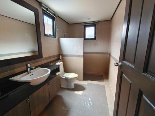 a bathroom with a sink and a toilet at Baan Natcha Villa in Pattaya Central