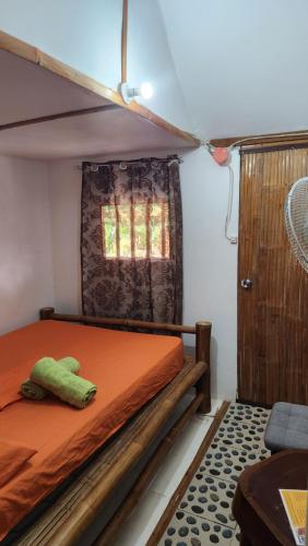 een slaapkamer met een bed met een groen knuffeldier erop bij Nirvana Bamboo & Dive resort in Moalboal