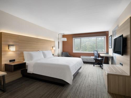 a hotel room with a large bed and a desk at Holiday Inn Express Fort Bragg, an IHG Hotel in Fort Bragg