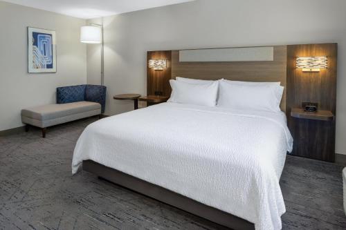 a hotel room with a large bed and a chair at Holiday Inn Express Hotel & Suites Vineland Millville by IHG in Vineland