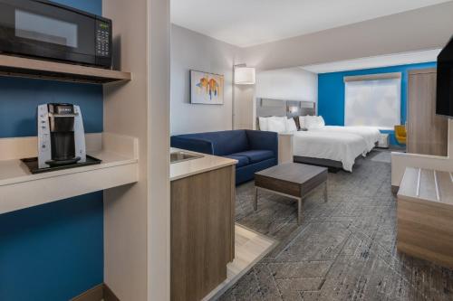 a hotel room with a bed and a living room at Holiday Inn Express Hotel & Suites Vineland Millville by IHG in Vineland