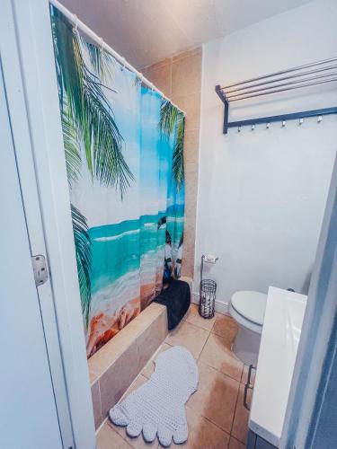 a bathroom with a palm tree mural on the wall at Playa Esmeralda One Bedroom Cottages in Bradenton Beach