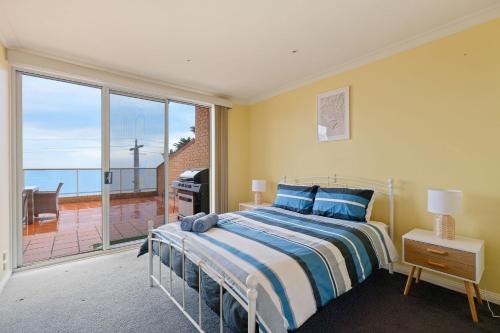 a bedroom with a bed and a large window at Beachfront Bliss - shared indoor pool & spa in Cowes