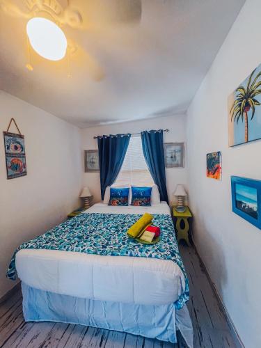 a bedroom with a bed with a yellow object on it at Playa Esmeralda One Bedroom Cottages in Bradenton Beach