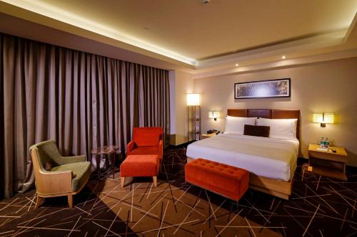 a hotel room with a bed and a chair at Holiday Inn Chennai OMR IT Expressway by IHG in Chennai