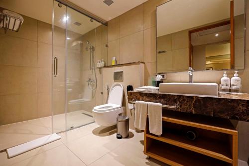 a bathroom with a toilet and a sink and a shower at Holiday Inn Chennai OMR IT Expressway by IHG in Chennai