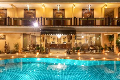 une grande piscine dans un bâtiment avec un hôtel dans l'établissement At Chiang Mai - SHA Extra Plus, à Chiang Mai