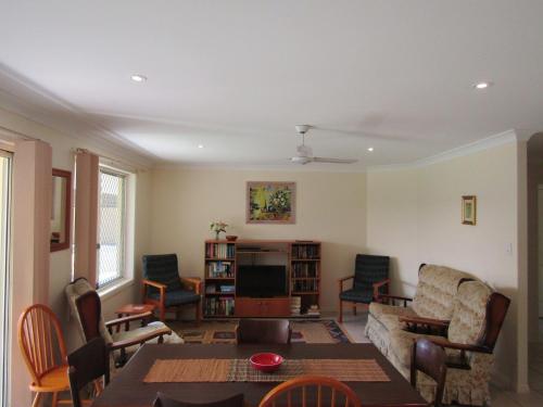 a living room with a couch and a table at Daintree House, Lennox Head in Lennox Head