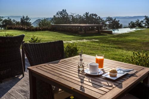 a wooden table with a cup of coffee and a plate of food at Estança La Pau - Adults Only in Mallá