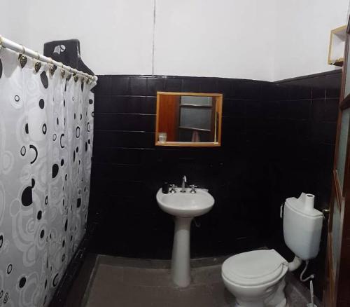 a black bathroom with a toilet and a sink at Alquiler de casa por día. in Santiago del Estero