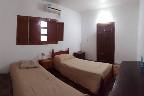 a room with two beds and a cabinet and a window at Alquiler de casa por día. in Santiago del Estero