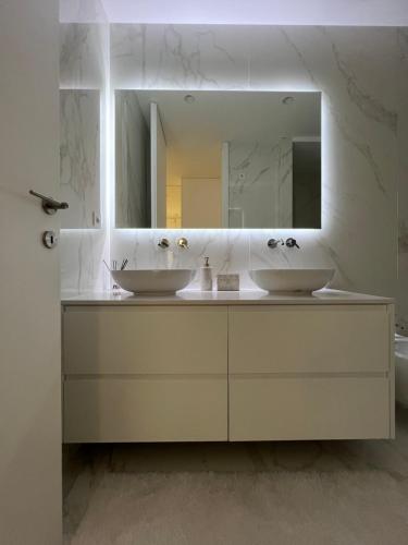 ein Badezimmer mit 2 Waschbecken und einem Spiegel in der Unterkunft The Convo Porto Apartments in Porto