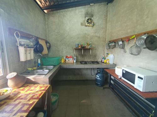 a small kitchen with a microwave and a sink at Pai happyvillage_yeon in Ban Thung Pong