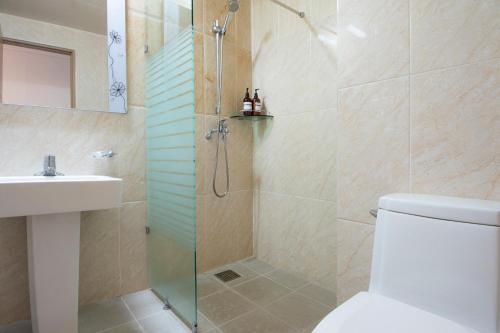 y baño con ducha, aseo y lavamanos. en Sims Hotel, en Jeju