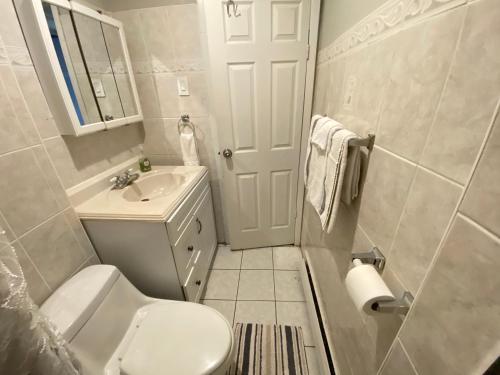 a small bathroom with a toilet and a sink at Charming and cozy apartment in New Jersey close to all the fun 10 minutes to NYC in West New York